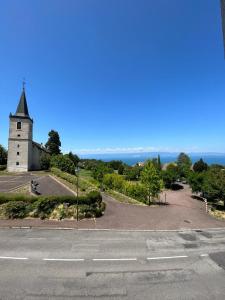 Una iglesia situada en la cima de una colina con una carretera en Lake view apartment, en Maxilly-sur-Léman