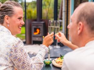 Una mujer sosteniendo una copa de vino junto a un hombre. en Holiday Home in Netherlands near Scenic Parks, en Andijk