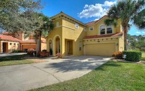 una casa amarilla con palmeras y entrada en Luxurious 5BR Watersong Resort Villa | Private South-Facing Pool and Spa, en Loughman