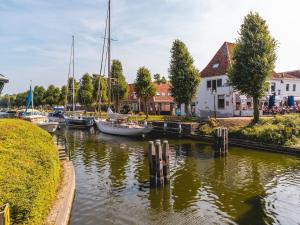 a group of boats docked in a river with houses at Holiday Home in Netherlands near Scenic Parks in Andijk +4 photos