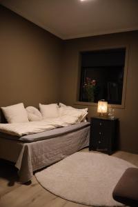 a bed with white sheets and pillows in a room at Forest lodge in Norskholmen