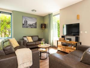 Una sala de estar con sofás y un televisor de pantalla plana. en Villa in Andijk with South-Facing Garden, en Andijk