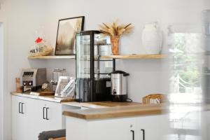 a kitchen counter with a coffee maker on a shelf at Oasis et Spa du Capitaine in Peribonka +10 photos