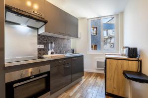 a kitchen with stainless steel appliances and a window at Le Pop-up, Spacieux-Hyper centre-Lumineux in Limoges