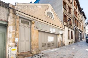 an old building with two garage doors on a street at Le Pop-up, Spacieux-Hyper centre-Lumineux in Limoges