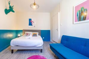 a bedroom with a bed and a blue couch at Le Pop-up, Spacieux-Hyper centre-Lumineux in Limoges