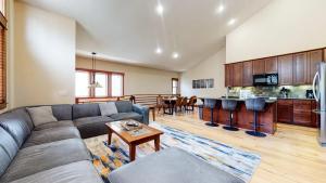 a large living room with a couch and a kitchen at Red Slate Canyon - Modern 2-Story Condo in Mammoth Lakes