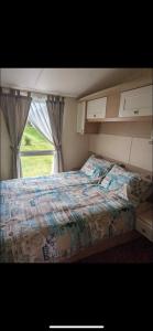 a bedroom with a large bed with a window at 20 Chestnut Grove in Stranraer