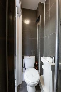 a bathroom with a white toilet and a sink at Jayjay Guest House in Basildon +8 photos