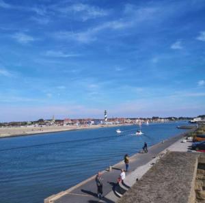 a group of people walking along the water near a beach at Aux flots d AuRa in Grand-Fort-Philippe