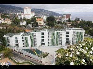 a large building with a swimming pool in a city at Quinta da Nogueira in Funchal