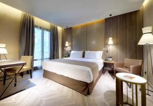 a hotel room with a large bed and a desk at Áurea Washington Irving by Eurostars Hotel Company in Granada