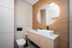 ウッチにあるŚwiętojańska Harmony Apartment by BookingHostの洗面台と鏡のあるバスルーム +15枚の写真