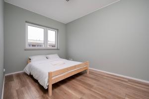 ウッチにあるŚwiętojańska Harmony Apartment by BookingHostのベッドと窓のある白い寝室