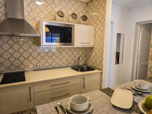 una cocina con fregadero y microondas en El Médano Sea Breeze, en El Médano 52 fotos más