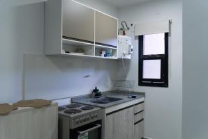 a kitchen with a stove and a sink and a window at México 1510 - Neuquén Centro in Neuquén