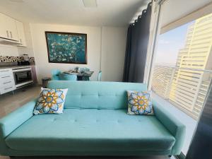a blue couch in a living room with a window at Apt Luxo VI no Shopping Df Plaza in Brasilia