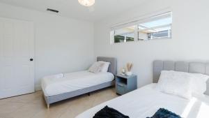 a bedroom with two beds and a window at Florida Paradyse 10MIN DOWNTOWN Y 10 MIN BEACH in Fort Myers +21 photos