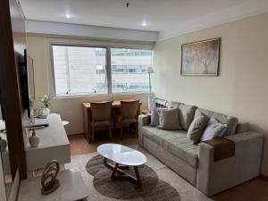 a living room with a couch and a table at Flat Conforto Luxo Vila Olimpia in Sao Paulo