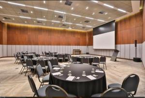a conference room with tables and chairs and a screen at Flat Conforto Luxo Vila Olimpia in Sao Paulo