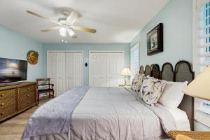 ein Schlafzimmer mit einem Bett und einem Deckenventilator in der Unterkunft Serene home with enclosed yard, grill, games, & central AC - dog-friendly in St. Augustine