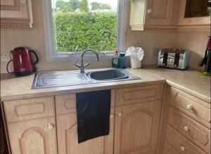 a kitchen counter with a sink and a window at Caravan at Harbour House in Moelfre
