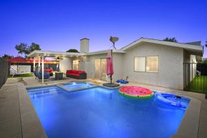 a swimming pool in front of a house at Heated Pool - Jacuzzi - Firepit - Game Room in Hemet