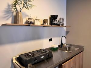 a kitchen with a stove and a sink at Aparta estudios primer piso con escritorio in Medellín +54 photos