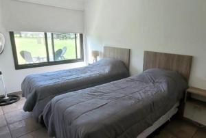 zwei Betten in einem Schlafzimmer mit Fenster in der Unterkunft Casa de Campo Vuelta de Obligado in Vuelta de Obligado