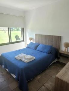 ein Schlafzimmer mit einem blauen Bett mit Handtüchern darauf in der Unterkunft Casa de Campo Vuelta de Obligado in Vuelta de Obligado