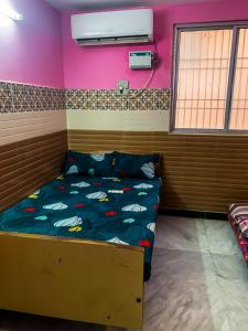 a room with a bed in a room with pink walls at MK Residency Rooms in Tiruvannāmalai