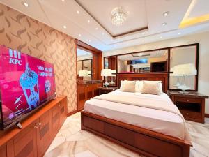 a bedroom with a large bed and a flat screen tv at Machala departamento lujo cerca del hotel oro verde in Machala