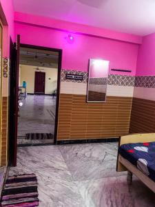 a room with pink walls and a room with a door at MK Residency Rooms in Tiruvannāmalai +4 photos