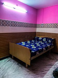 a bedroom with a bed in a room with pink at MK Residency Rooms in Tiruvannāmalai