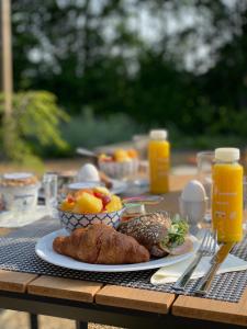 a table with a plate of food and fruit on it at Marina Strandbad TinyHouse Pawradise in Olburgen