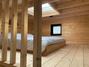 a bedroom with a bed in a wooden room at Marina Strandbad TinyHouse Pawradise in Olburgen