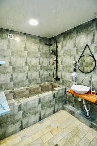 a bathroom with a sink and a tub at Art Hotel Home in Tbilisi City
