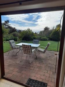 un tavolo e delle sedie seduti su un patio di Abel Tasman Kaiteriteri Garden & Sea View Apartment a Kaiteriteri