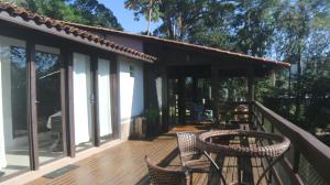 a house with a deck with chairs and windows at Casa Reserva Encantada in Garopaba