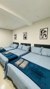 three beds in a room with blue sheets at Casa Família no Parque Edu Chaves in Sao Paulo
