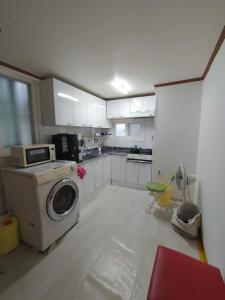 a kitchen with a washing machine in the middle of it at Sinchon House close to the airport in Seoul