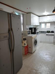 a kitchen with a refrigerator and a washing machine at Sinchon House close to the airport in Seoul +17 photos