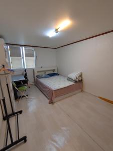 a room with a bed and a painting in it at Sinchon House close to the airport in Seoul