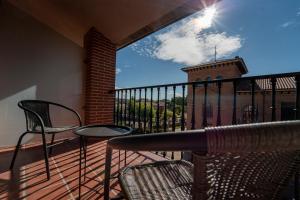 a balcony with chairs and a table and a building at Olmedo Hostal Plaza in Olmedo +23 photos