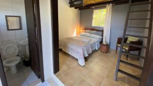 a bedroom with a bed and a bathroom with a ladder at Casa Reserva Encantada in Garopaba +13 photos