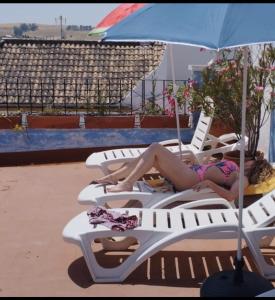 two women laying on lounge chairs on the beach at BED FOR 2 IN TYPICAL AREA I in Córdoba
