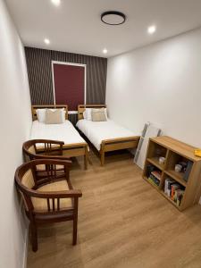 a room with two beds and a table and chairs at Modern East London Apartment with Private Studio & Guest Rooms-Near Bow, Victoria Park in London