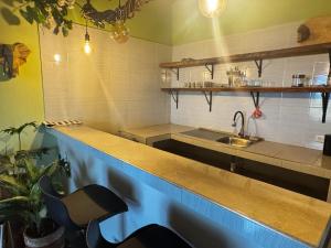 cocina con fregadero y barra con silla en Casa Colibri - Hostel, en Pueblo Bello 17 fotos más