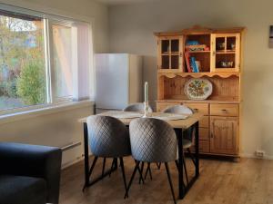 Una cocina con mesa y sillas y un refrigerador. en Warm and cosy apartment, en Tromsø