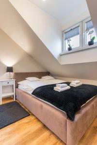 a bedroom with a large bed with towels on it at Apartament Filipek in Szczawnica